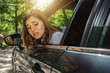 © Pintau Studio - Portrait of woman in car looking out the window with worried face maybe because scratched car or accident on back side.