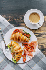 Poster - The concept of a hearty and tasty breakfast of fresh classic croissants with a variety of toppings from ricotta jamon avocado, strawberries, sun-dried tomatoes, and French mustard.