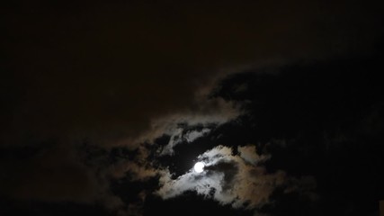 Wall Mural - the moon shines brightly in the night sky through the clouds