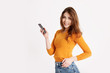 Portrait of a young pretty girl in a yellow sweater with a phone in her hands. The girl communicates using a mobile phone
