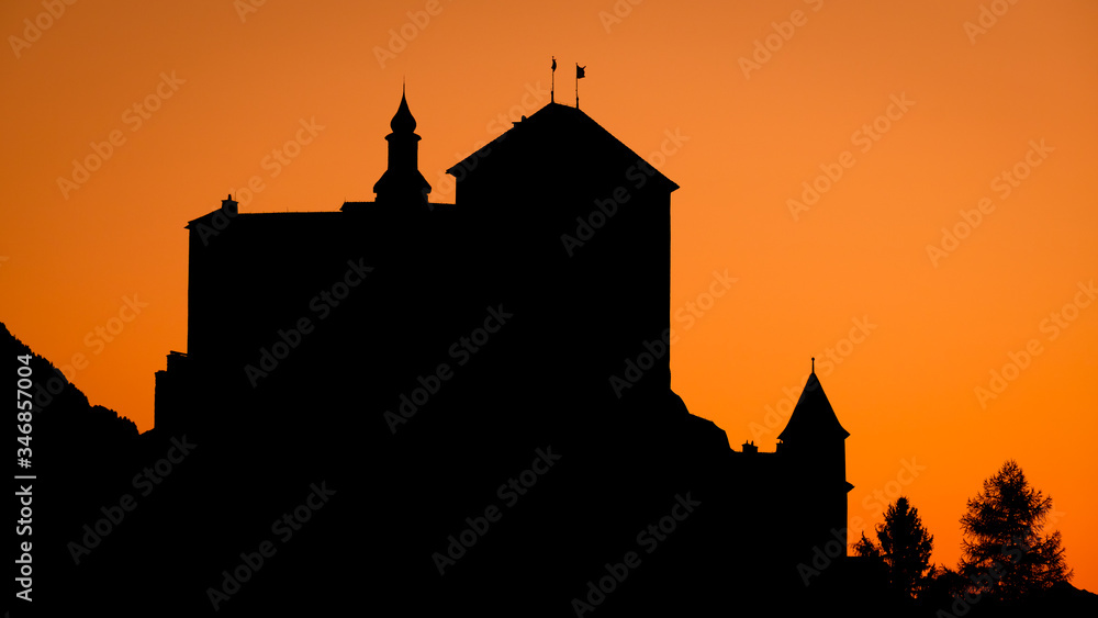 Sun is setting at the mountains surrounding Tarasp and its castle, in ...
