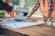 © visoot - Engineer working with laptop and blueprints,engineer inspection in construction site for architectural plan,sketching a construction project.