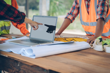 Engineer working with laptop and blueprints,engineer inspection in construction site for architectural plan,sketching a construction project.