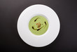 Green cream soup in white bowl