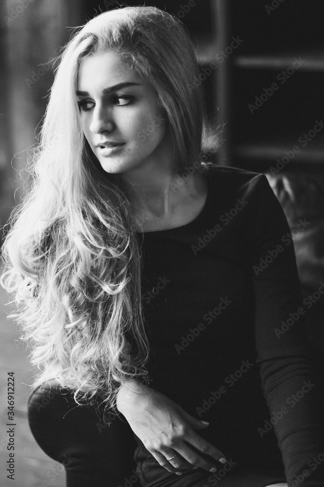 Beautiful Woman Looking Away While Sitting On Chair At Home - obrazy, fototapety, plakaty 