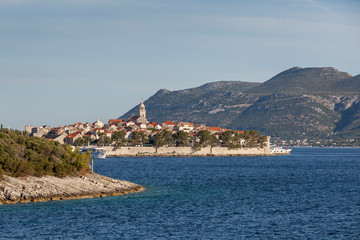 Wall Mural - Defended medieval dalmatian town Korcula on the island of Korcula and mountains on Peljesac peninsula in background, Croatia