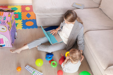 Busy young mother working from home with child. Freelance and motherhood concept