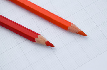 Wall Mural - Red and a orange color wood pencil crayon placed beside one another on a white background