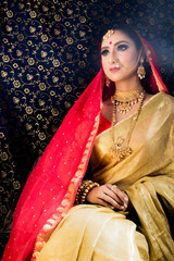 Wall Mural - Indian Bridal wear in a golden and red saree and royal jewellry
