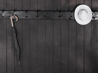 Wall Mural - hat on a black wooden hanger on a black wooden wall