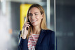 © Westend61 - Portrait of smiling businesswoman on the phone in office
