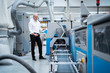© Westend61 - Businessman standing at a machine in a factory