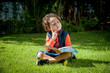 © Hermes Bezerra  - Menino brincando com livro no gramado