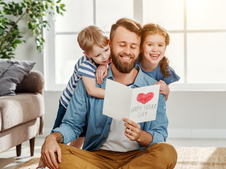 Wall Mural - happy father receiving greeting card from kids.