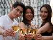 © natsarun - Group of asian friend cheering and drinking at terrace party. Young people toasting glass with wine at rooftop restaurant. Friendship ,youth lifestyle and nightlife concept.