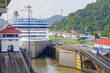 Modern white Panamax cruiseship or cruise ship liner transit through old Miraflores locks at Panama Canal