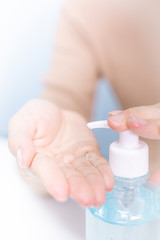  Business woman washing his hands with an alcohol gel in a pump-like bottle to prevent the spread of the Covid-19 virus.