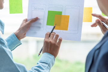 designer men pointing stick note planning develop application develop for mobile phone.
