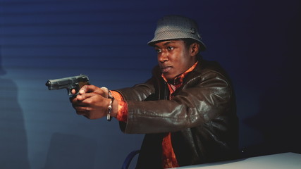 Wall Mural - Close-up of black criminal grabbing the gun and threatening to harm cops. He trying to escape from interrogation room.