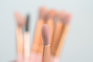 several pink and gold makeup brushes