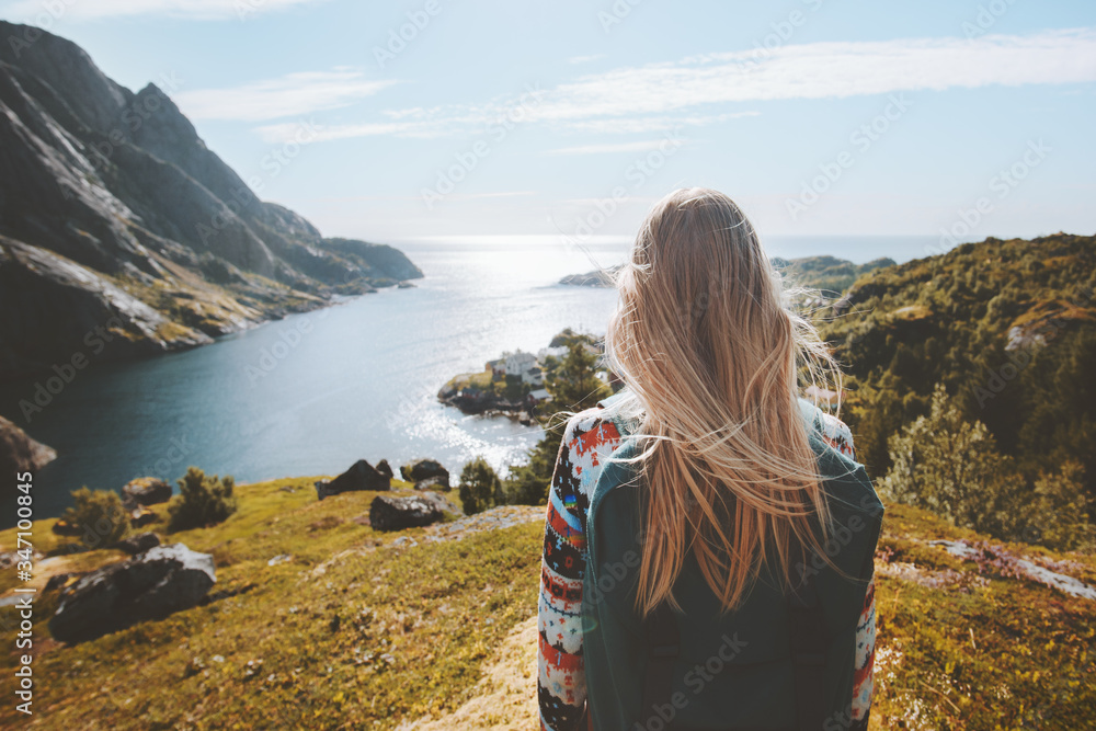 Woman traveler walking alone enjoying sea view outdoor travel summer vacations healthy lifestyle girl with backpack in Norway - obrazy, fototapety, plakaty 