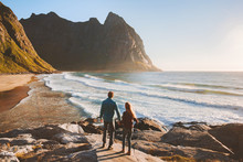 Couple Walking On Kvalvika Beach Travel Romantic Vacations Outdoor Healthy Lifestyle Man And Woman Together Enjoying Ocean And Rocks Landscape In Norway Lofoten Islands Summer Trip