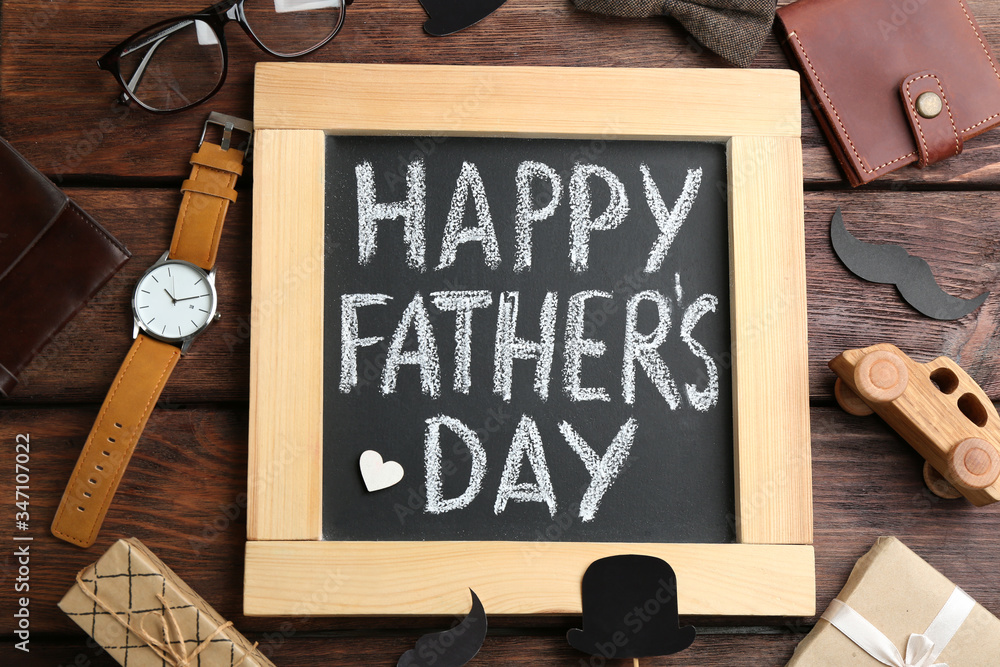 Blackboard with words HAPPY FATHER'S DAY and male accessories on wooden background, flat lay - obrazy, fototapety, plakaty 