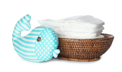 Wall Mural - wicker bowl with disposable diapers and toy on white background