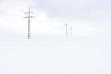 Snowy Landscape With Electric Tower And Old Fences