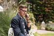 © Pituk - Young business man sitting on outdoor bench and using a smartphone