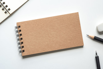 Wall Mural - close up. kraft paper cover spiral notebook with pencil, eraser and open notebook on white backgroun