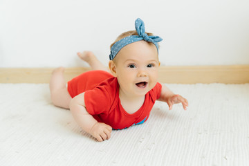 Wall Mural - cute happy baby girl in red jumpsuit on white background 