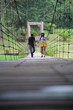 © pantkmutt - Women and men walk hand in hand on the wooden suspension bridge in Khlong Wang Chao Kamphaeng Phet National Park, Thailand