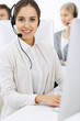 Call center. Group of diverse operators at work. Beautiful woman in headset communicating with customers of telemarketing service. Business concept