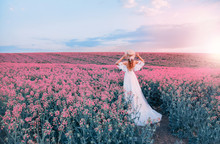 Silhouette Woman. White Long Vintage Dress. Princess Medieval Lady In Historical Clothes. Straw Hat Boater Flowers. Aroma Spring Nature Pink Flowering Field, Blue Sky Sunset Sun Light. Back Rear View