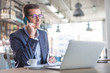 © weyo - Male businessman calls on a cell phone looking into the notebook, having a coffee in the restaurant