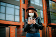 © Катя Іваськевич - young woman with mobile phone in the city in mask. coronavirus. covid-19.