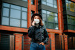 © Катя Іваськевич - young woman with mobile phone in the city in mask. coronavirus. covid-19.