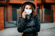 © Катя Іваськевич - young woman with mobile phone in the city in mask. coronavirus. covid-19.
