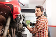 © 1001color - Motorbike repairman working in repair shop.