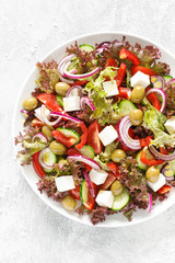 Wall Mural - Greek salad with fresh vegetables, lettuce and feta cheese