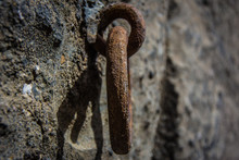 Close-up Of Rusty Metallic Ring Mounted In Concrete Wall