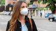© zigres - COVID-19 Pandemic Coronavirus Woman in city street wearing KN95 FFP2 mask protective for spreading of disease virus SARS-CoV-2. Girl with protective mask on face against Coronavirus Disease 2019.