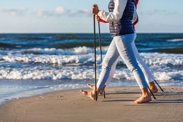 Wall Mural - Nordic walking - two women working out on beach