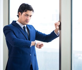 Poster - Young handsome businessman standing at the window