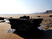 Rock Formation On Beach Against Clear Sky