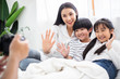 © winnievinzence - Happy Asian mother, son and daughter waving hand greeting to camera. social distancing lifestyle living insurance. career chance, father hand recording family VDO vlog during Coronavirus. stay home