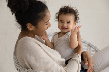 Wall Mural - loving young african american mother hold embrace cute little ethnic infant toddler, caring biracial