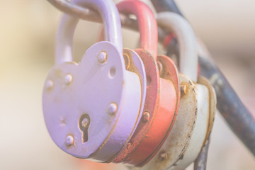 Wall Mural - The colorful large metal padlocks in the form of hearts and with rusty from time metal enshrined. The concept of divorce, quarrel, separation of a married couple.