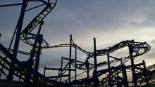 Low Angle View Of Roller Coaster Against Cloudy Sky During Sunset